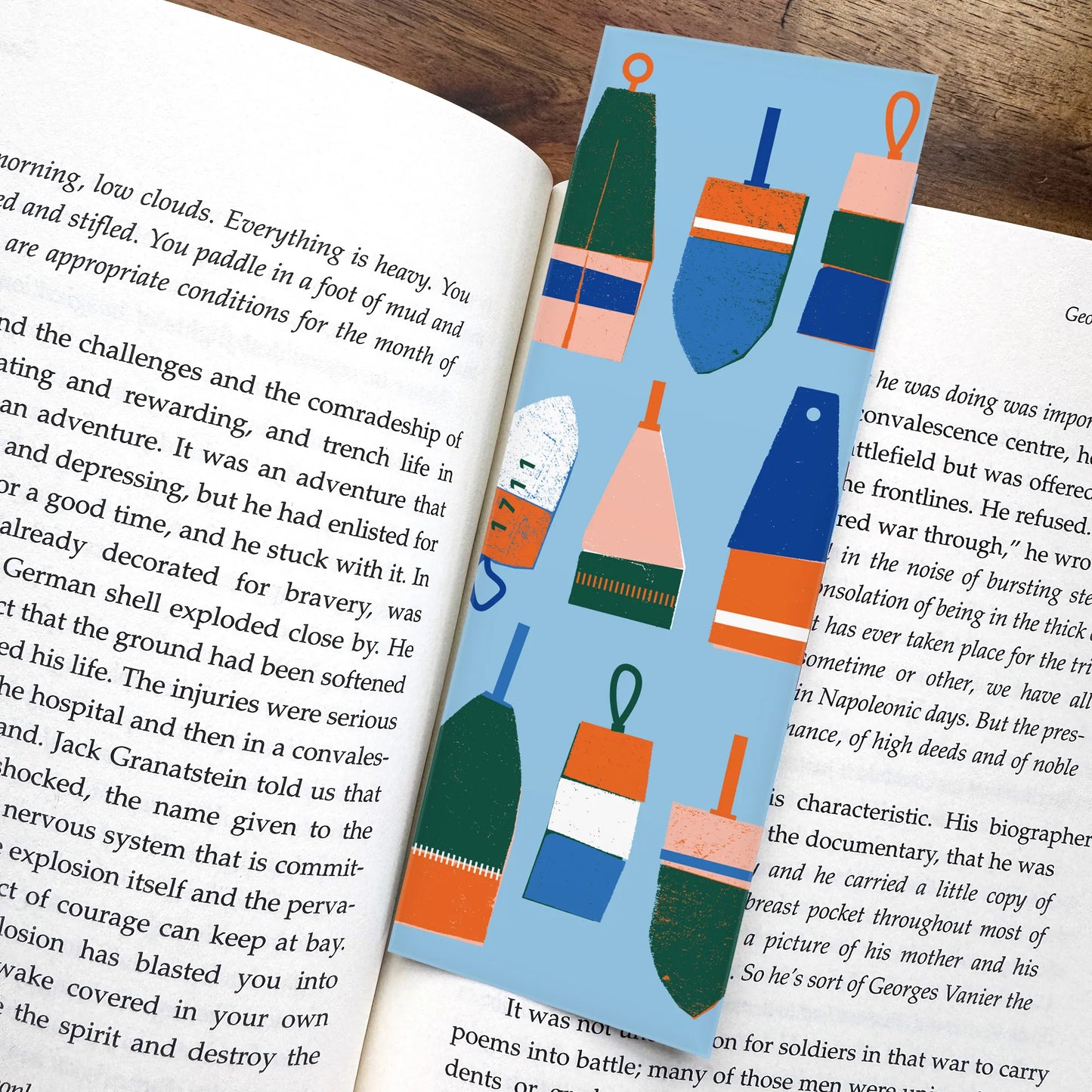 Buoy-themed bookmark nestled in an open book, featuring colourful East Coast illustrations. A playful piece of Nova Scotia art and a charming Maritime gift.