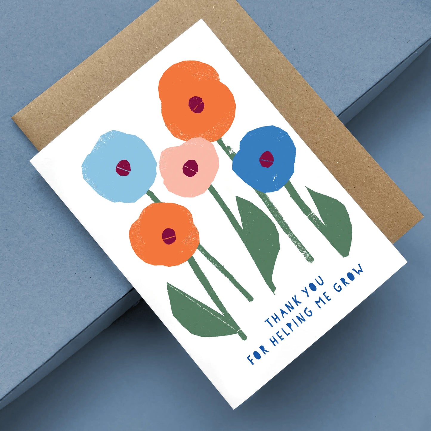 Greeting Card Helping me Grow featuring colorful minimalist flowers in orange, blue, and pink with green stems on white card with kraft envelope