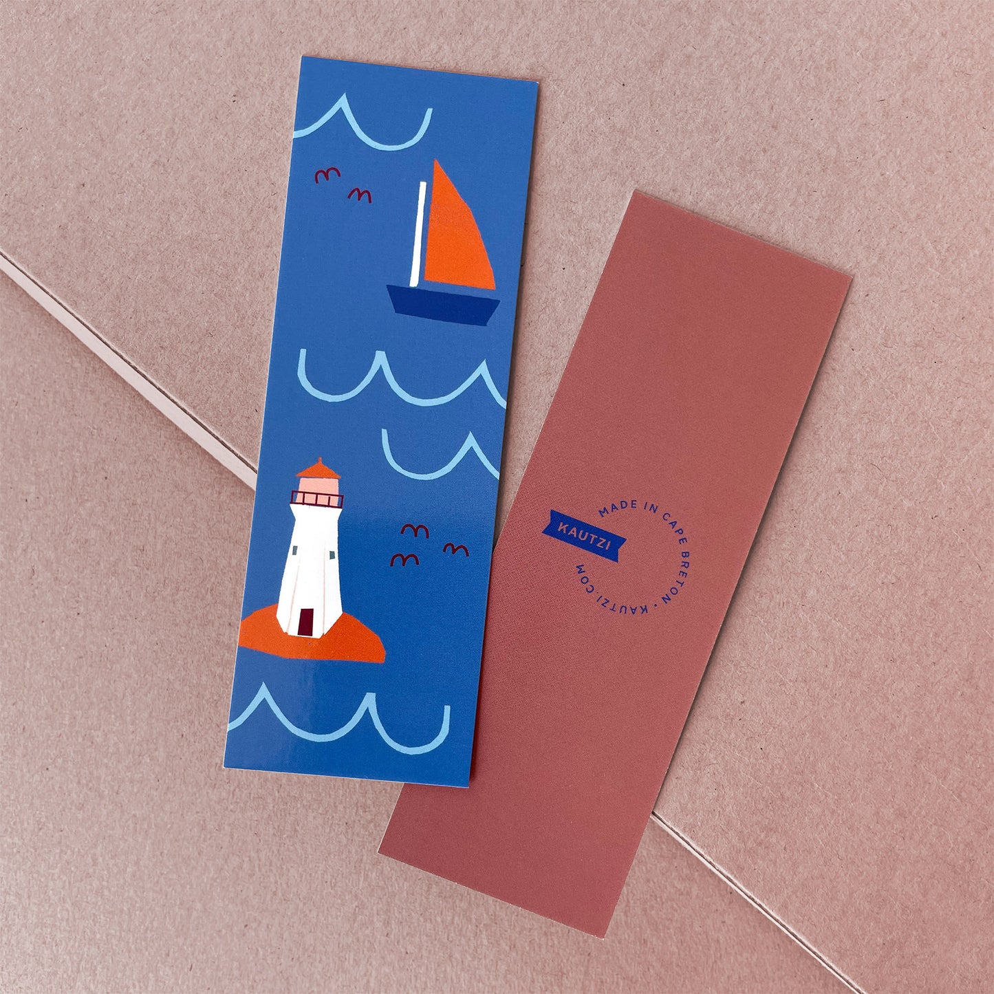 Seaside Bookmark featuring a whimsical lighthouse and sailboat design on blue background with waves and seagulls Bookmarks All Printed Goods