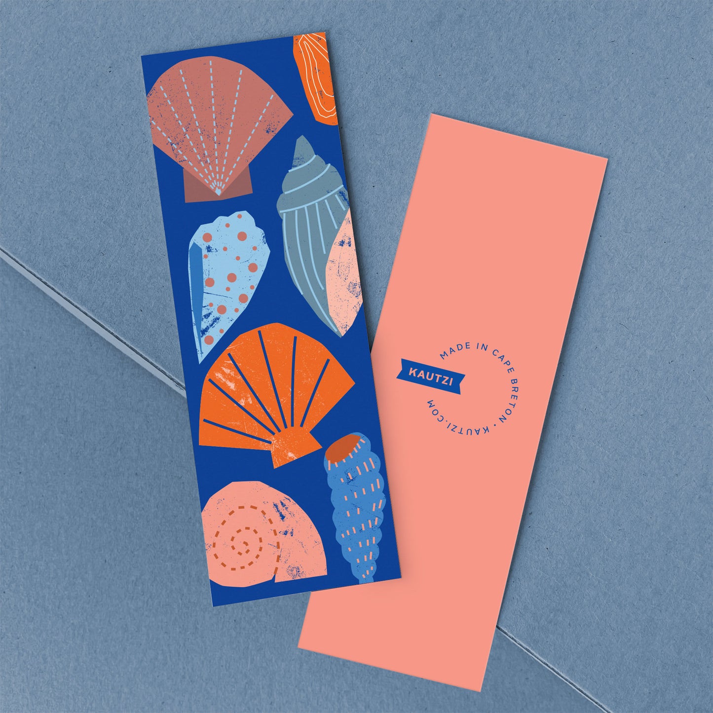 Colourful shell bookmark featuring vibrant maritime seashell illustrations on deep blue background, Kautzi logo on coral reverse.