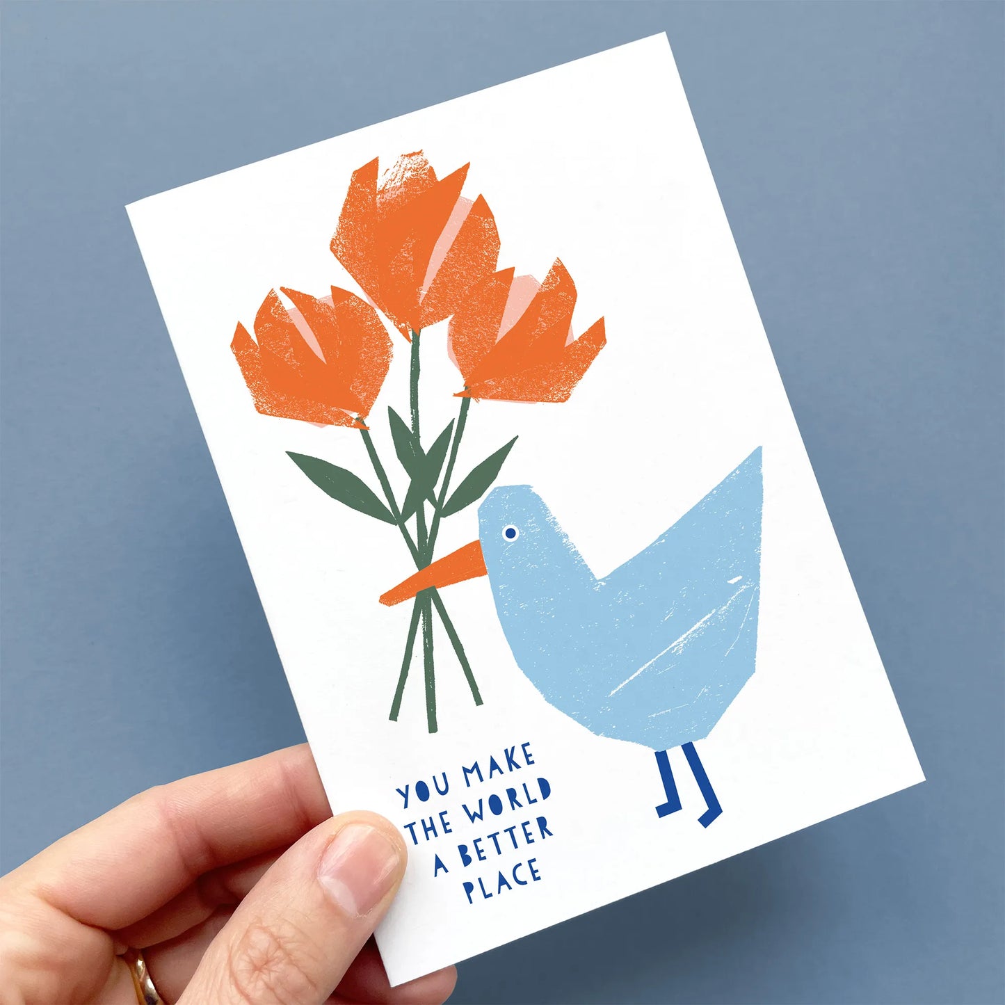 Kautzi greeting card with a seagull holding flowers, displayed in hand, with the message "You make the world a better place."