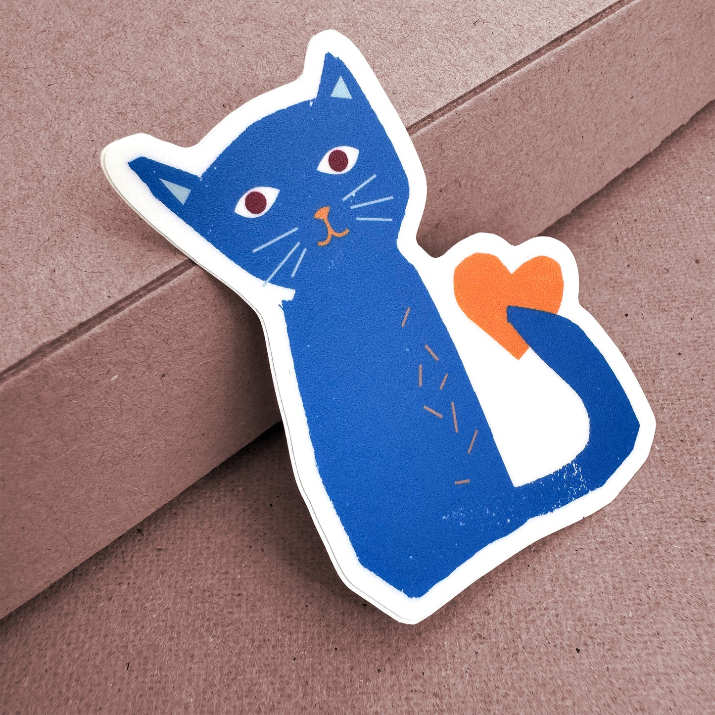 Sticker Cat - Adorable blue vinyl cat sticker with red eyes and orange heart, perfect for decorating surfaces