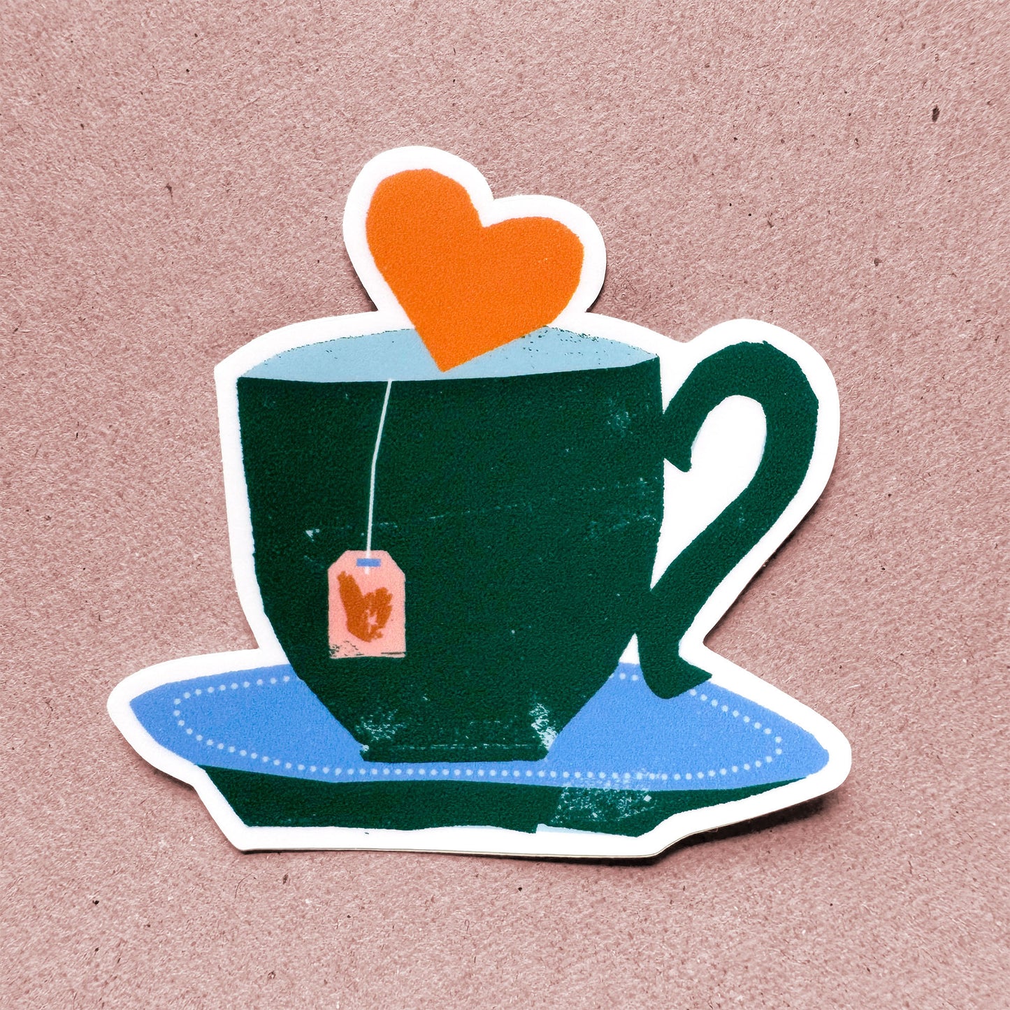 Green teacup sticker with orange heart floating above and tea bag, blue saucer, Cup of Tea design for tea lovers