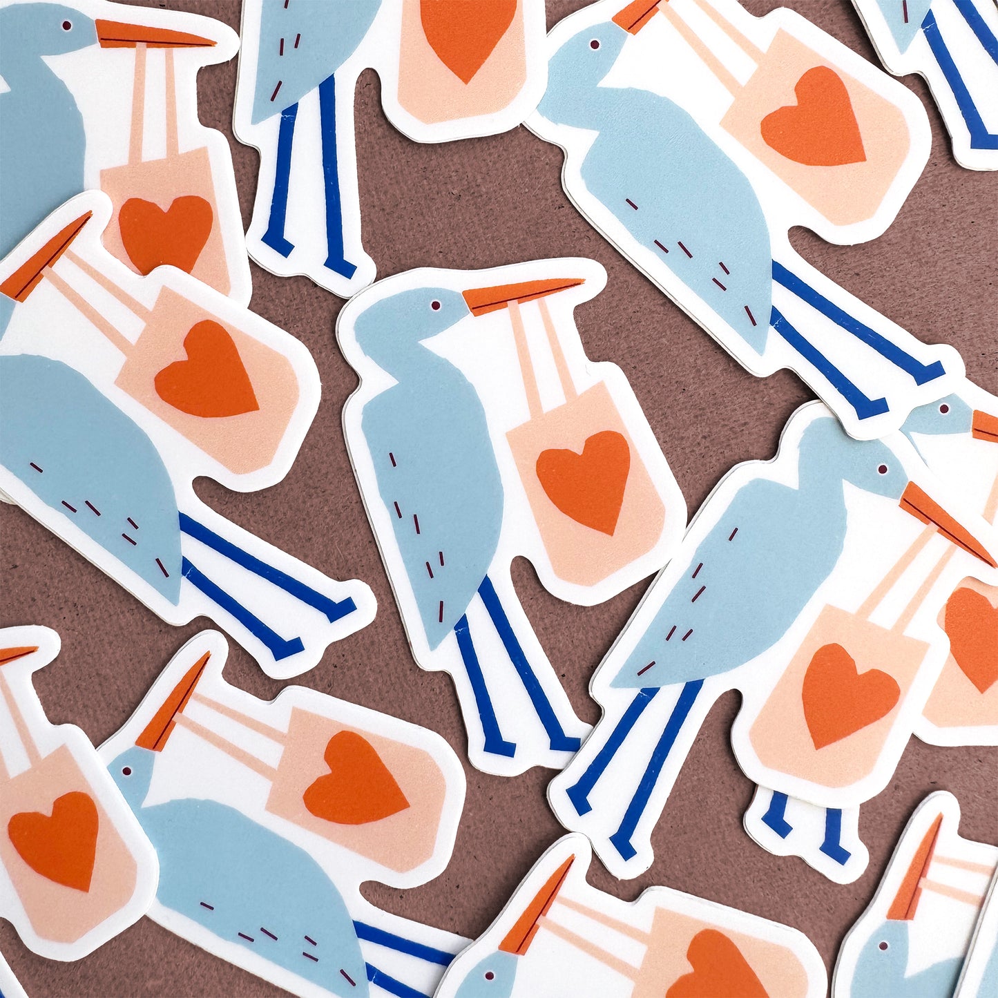 Sticker Heron - Cute blue heron vinyl sticker design with orange heart and blue stripes pattern on white background