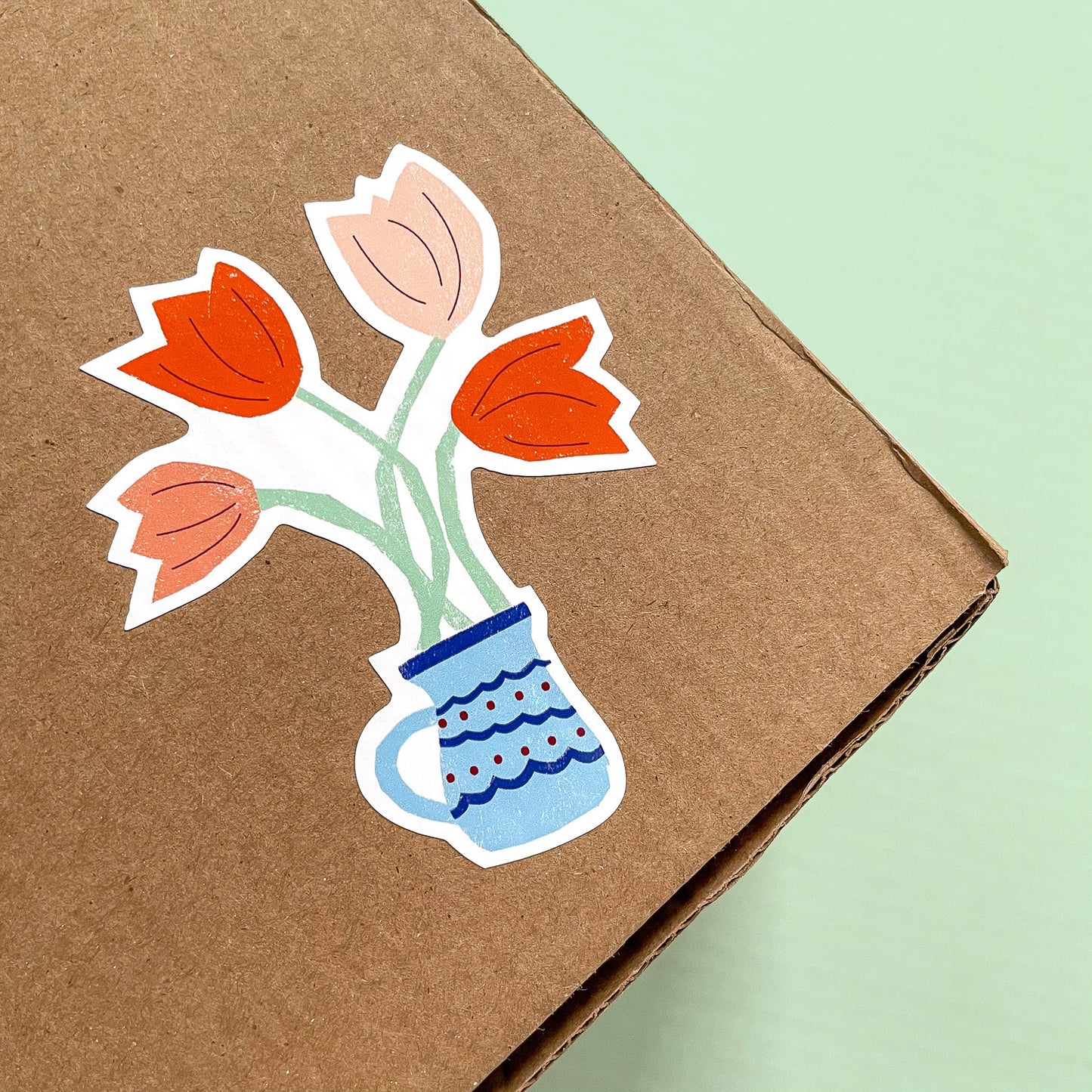 Sticker Tulips vinyl decal featuring pink and orange tulips in a decorative blue vase on kraft background