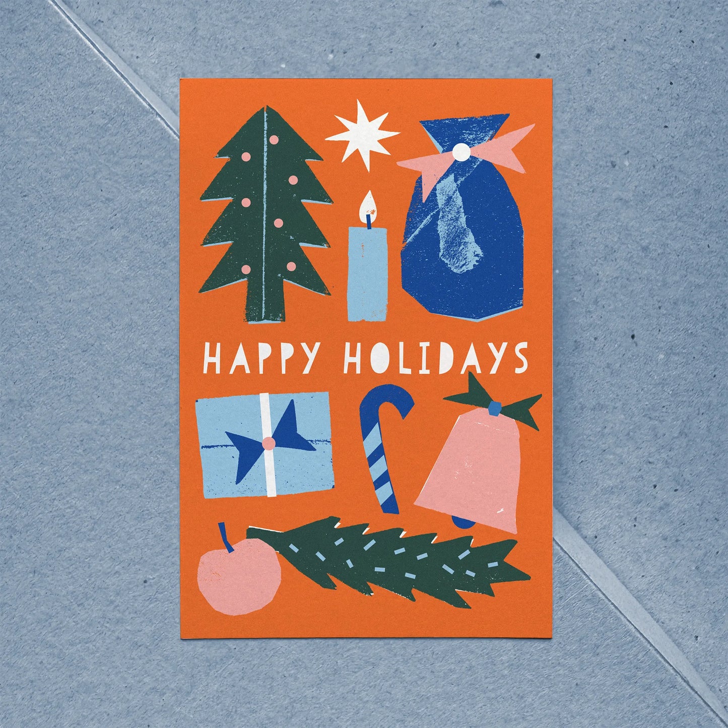 Full view of flat Christmas card with bold illustration featuring tree, gift, bell, candle, and candy cane.