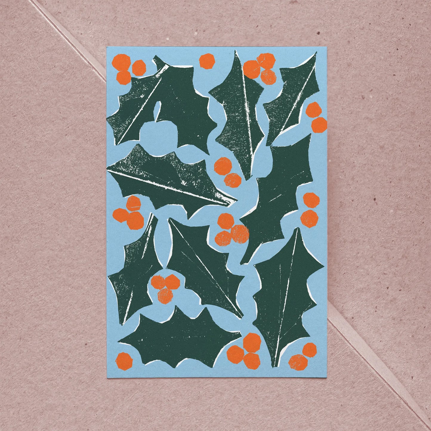 Full front view of holiday card showing holly leaves and orange berries in bold graphic style.