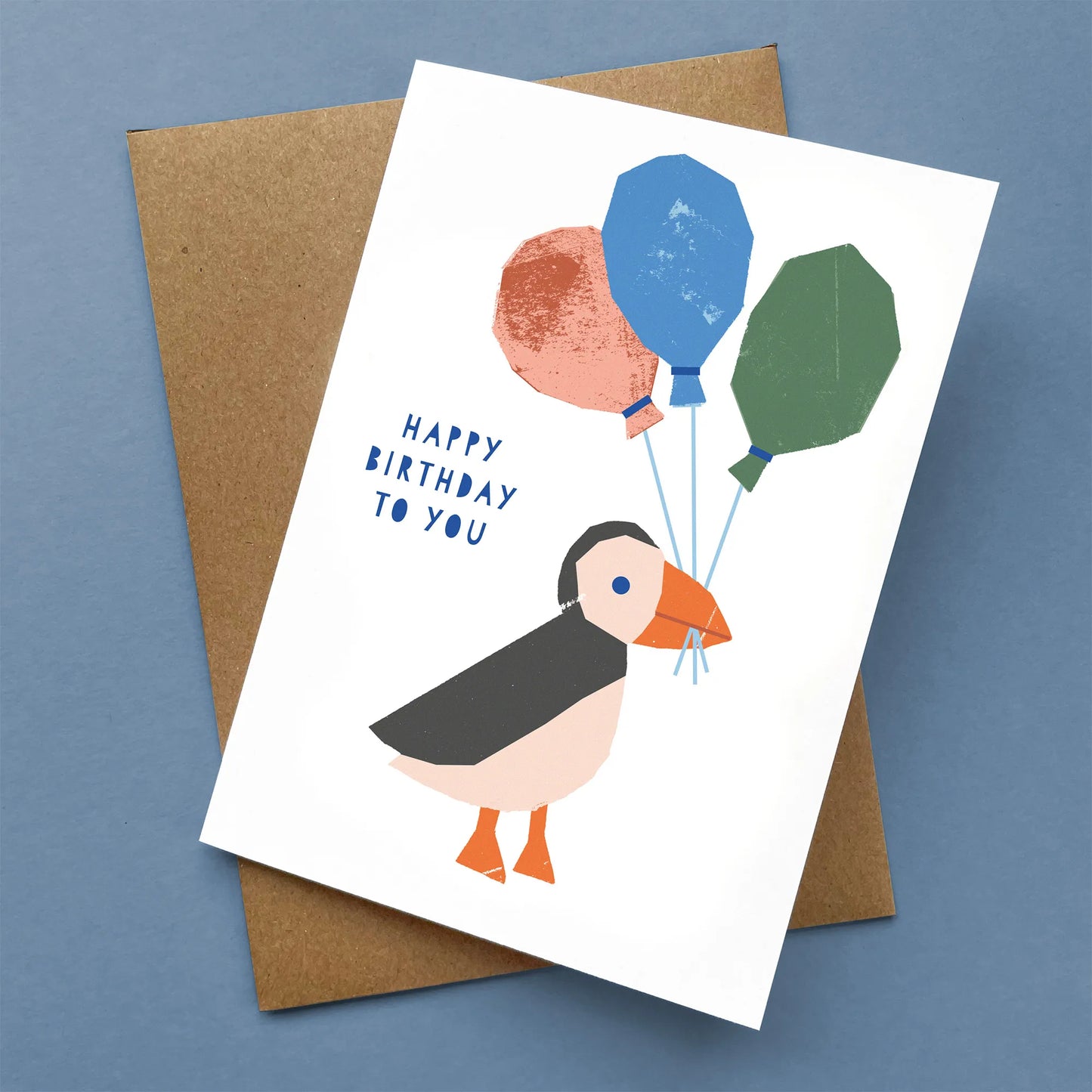 Kautzi illustrated puffin birthday card shown flat with Kraft envelope, bold graphic design, Cape Breton, Nova Scotia, Canada