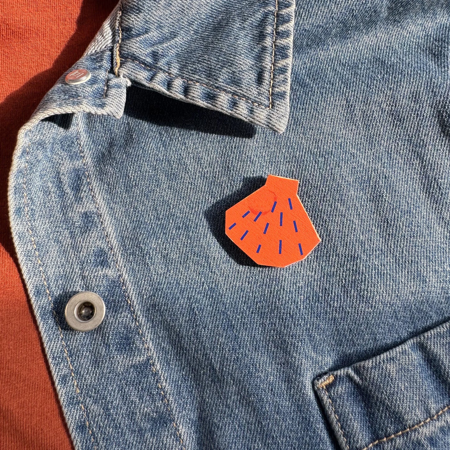 Kautzi maple wood veneer shell pin badge attached to denim jacket, Maritime beachcomber style