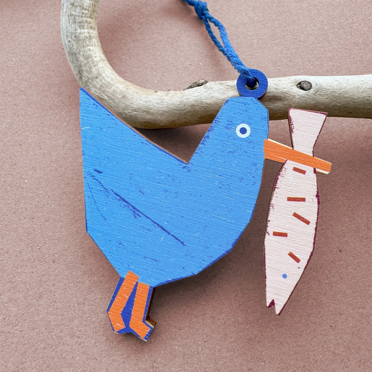 Blue wooden seagull ornament holding a fish, designed by Kautzi in Cape Breton, Nova Scotia.