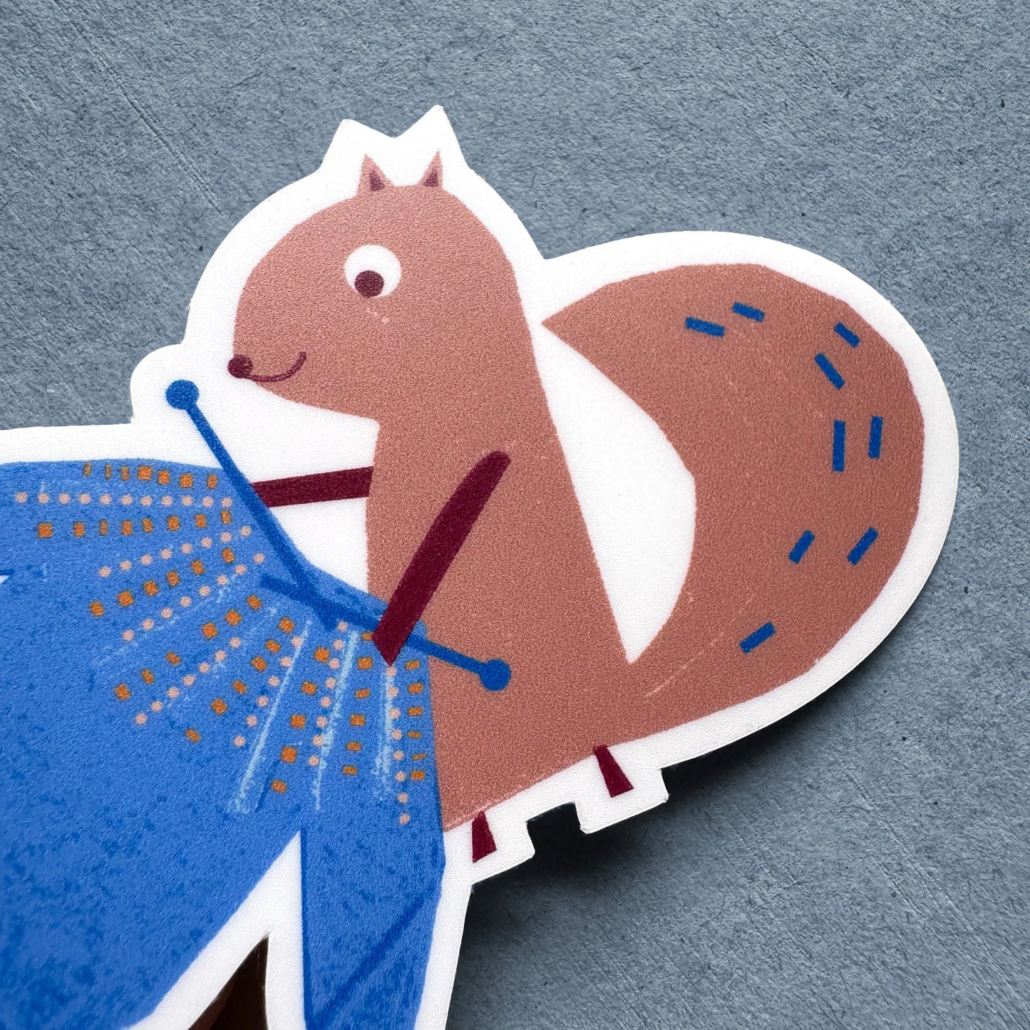 Close-up of Kautzi Knitting Squirrel sticker – Cape Breton–based illustration of a squirrel knitting a blue sweater, designed in Nova Scotia.