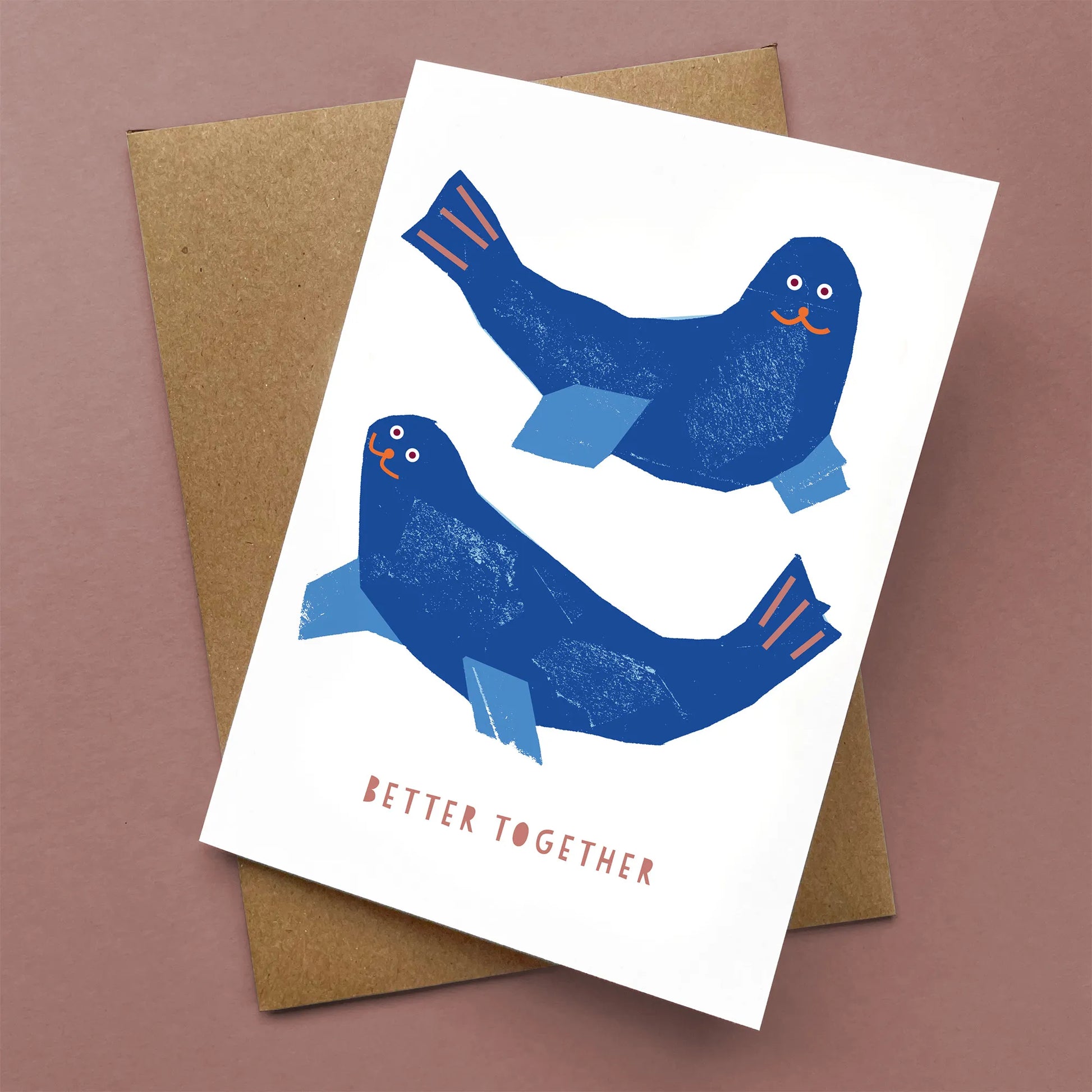 Kautzi Better Together greeting card with two blue seals and playful text, shown flat with a brown kraft envelope.