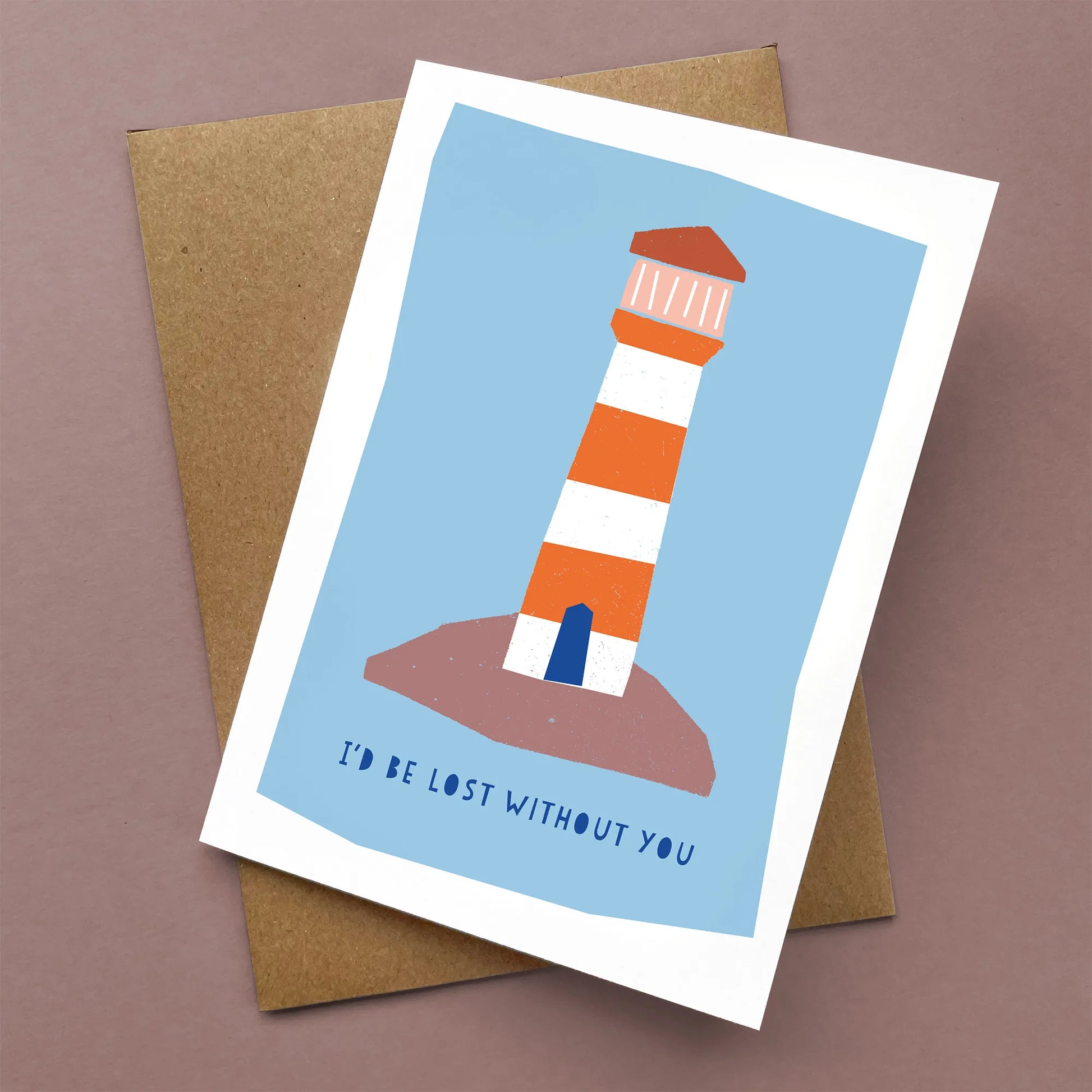 Kautzi Lost Without You greeting card with a red and white lighthouse on a blue background, shown flat with a brown kraft envelope.