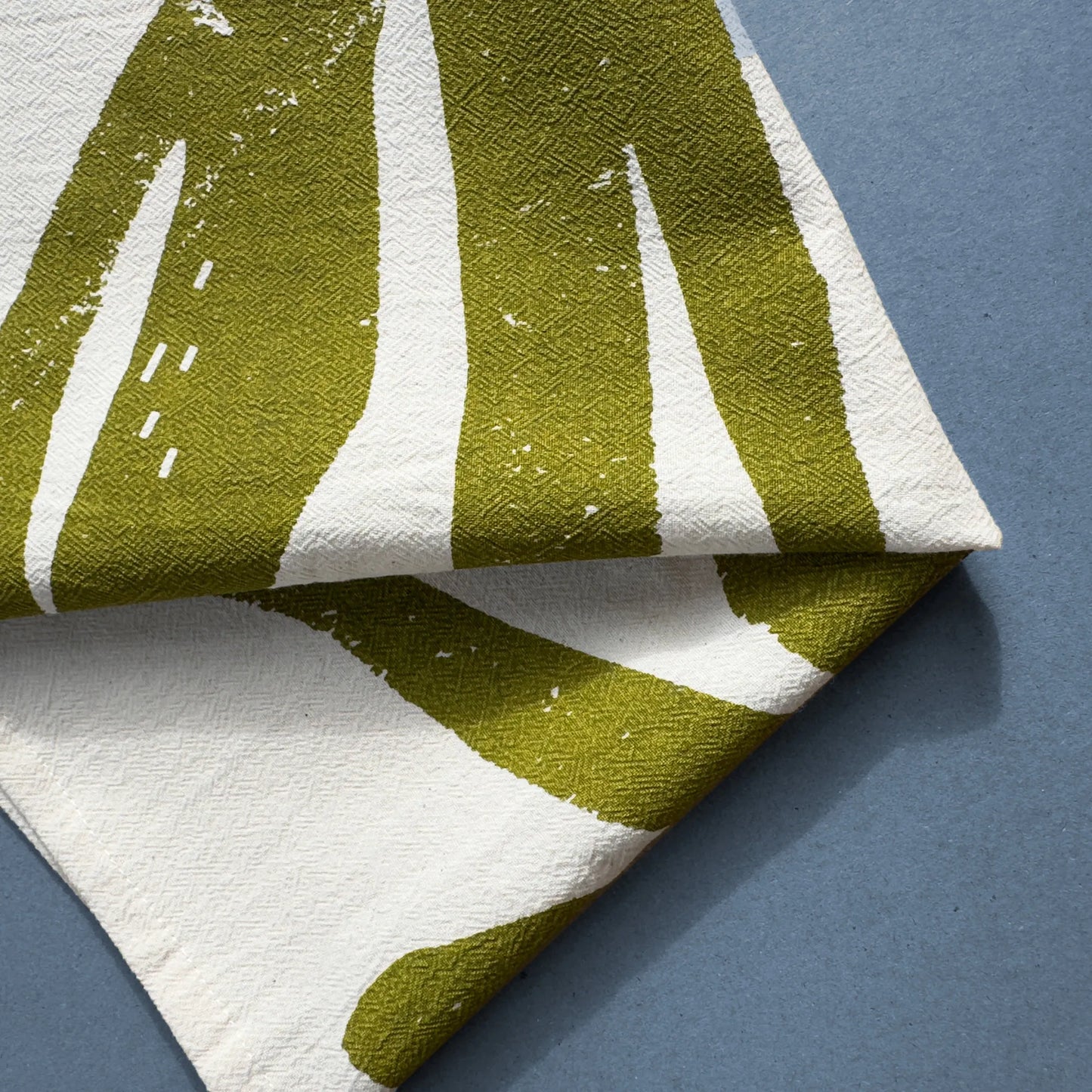 Close-up of the Ocean Harvest tea towel by Kautzi, featuring an abstract seaweed-inspired design in deep olive green, screen-printed on flour sack cotton.