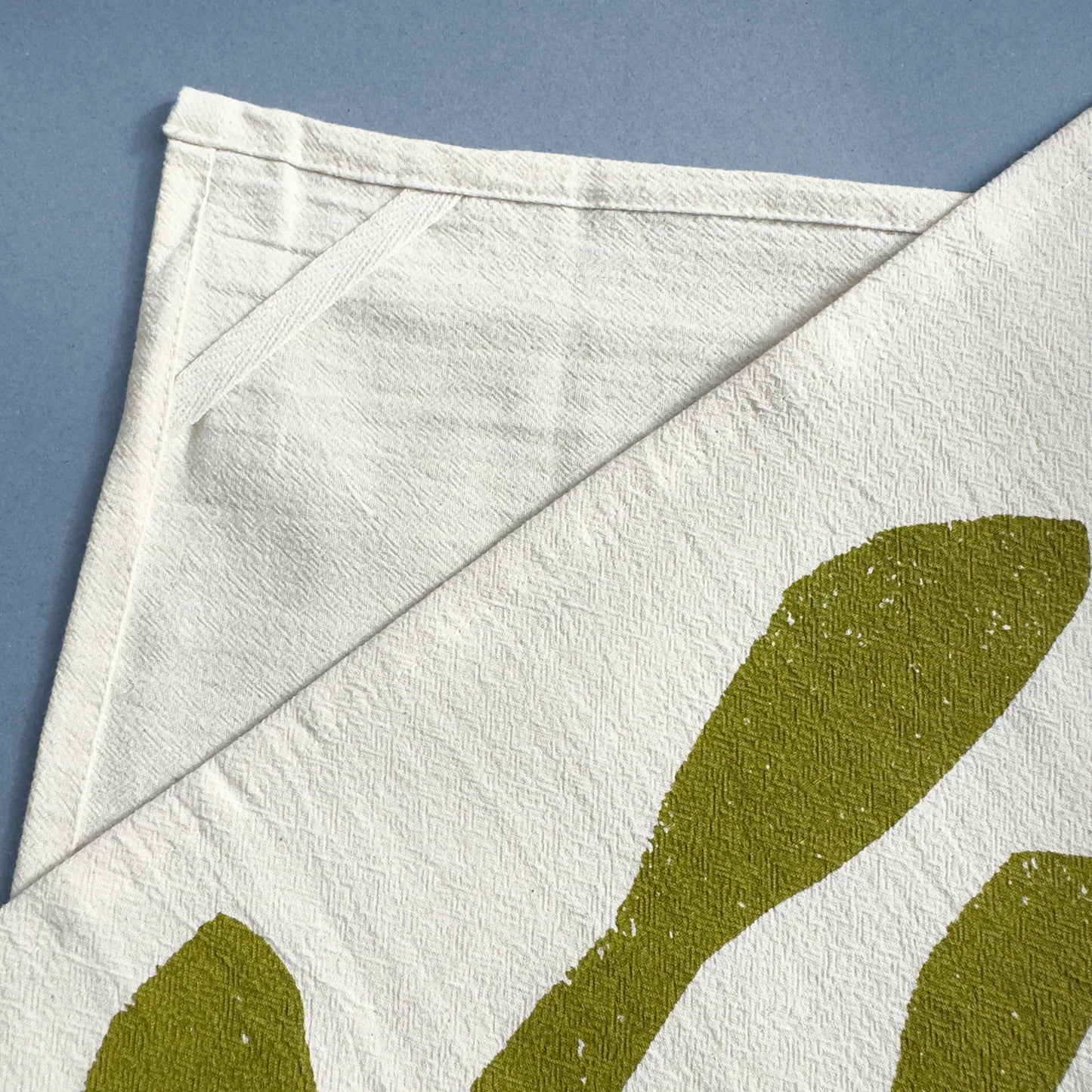 Backside detail of the Ocean Harvest tea towel by Kautzi, highlighting the sewn-in hanging loop for convenient storage.