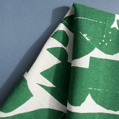 Close-up of the Rolling Hills tea towel by Kautzi, featuring a bold green and white abstract landscape design, screen-printed on flour sack cotton.