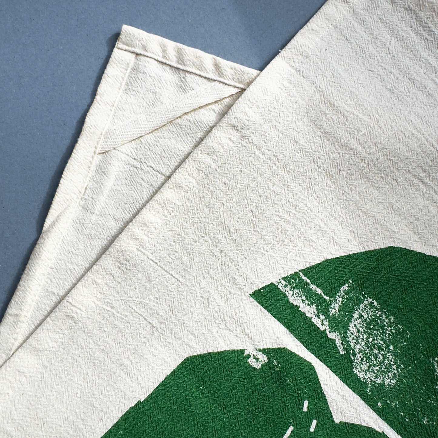 Backside detail of the Rolling Hills tea towel by Kautzi, showing the hanging loop sewn into the natural flour sack cotton fabric.