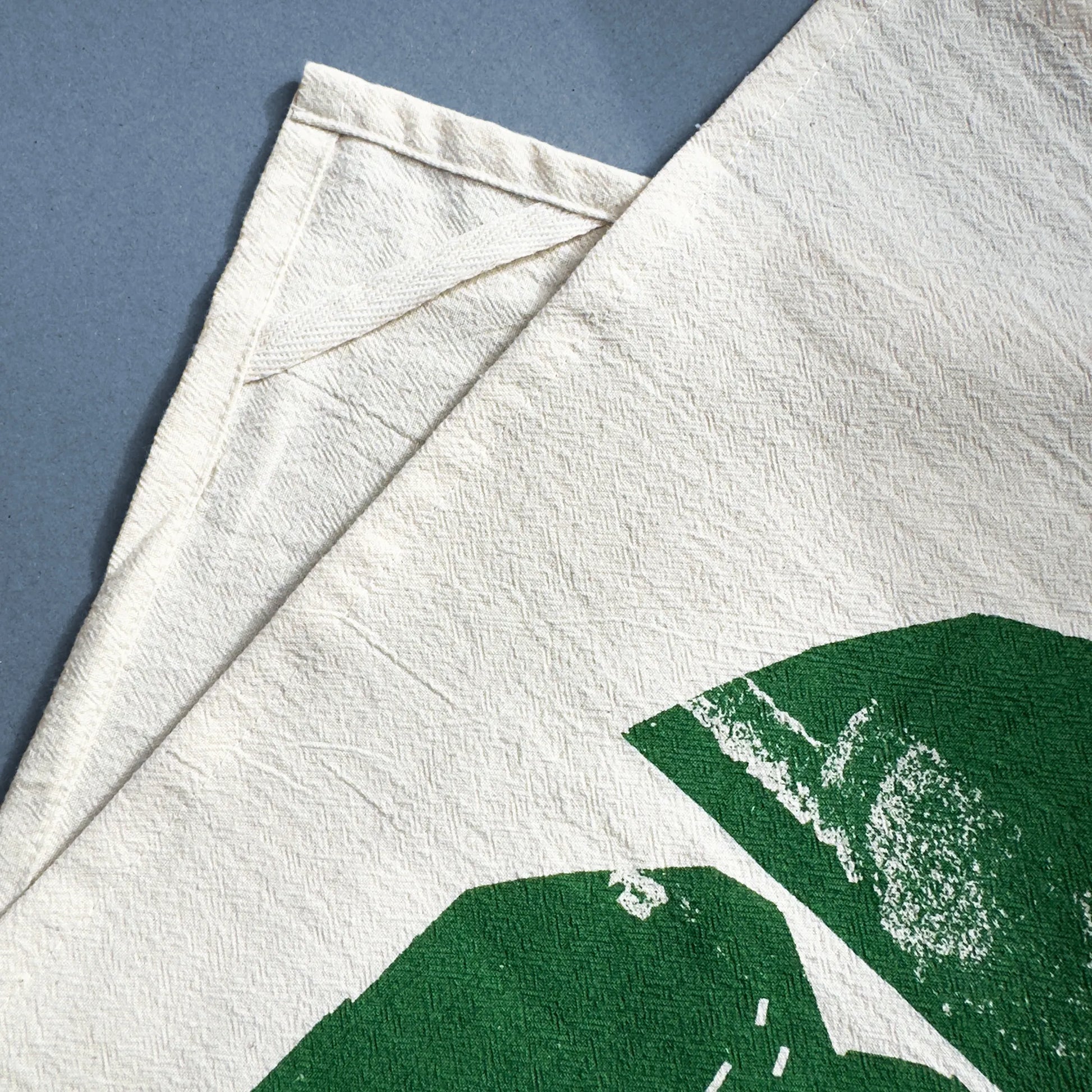 Backside detail of the Rolling Hills tea towel by Kautzi, showing the hanging loop sewn into the natural flour sack cotton fabric.