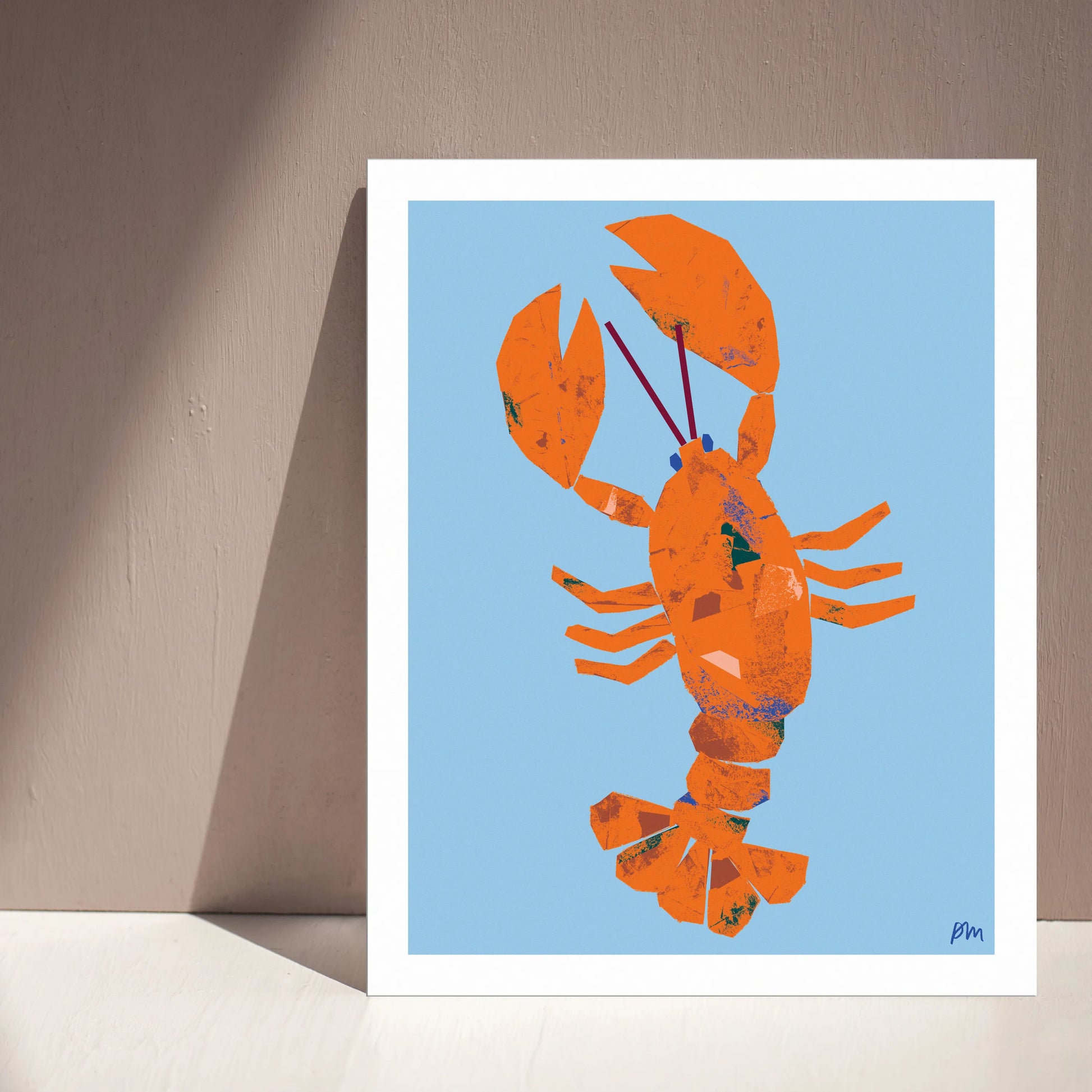 Kautzi Illustrations 8×10 Lobster art print leaning against a wall with natural light and shadows, featuring an orange lobster on a light blue background, inspired by East Coast and Maritime themes.