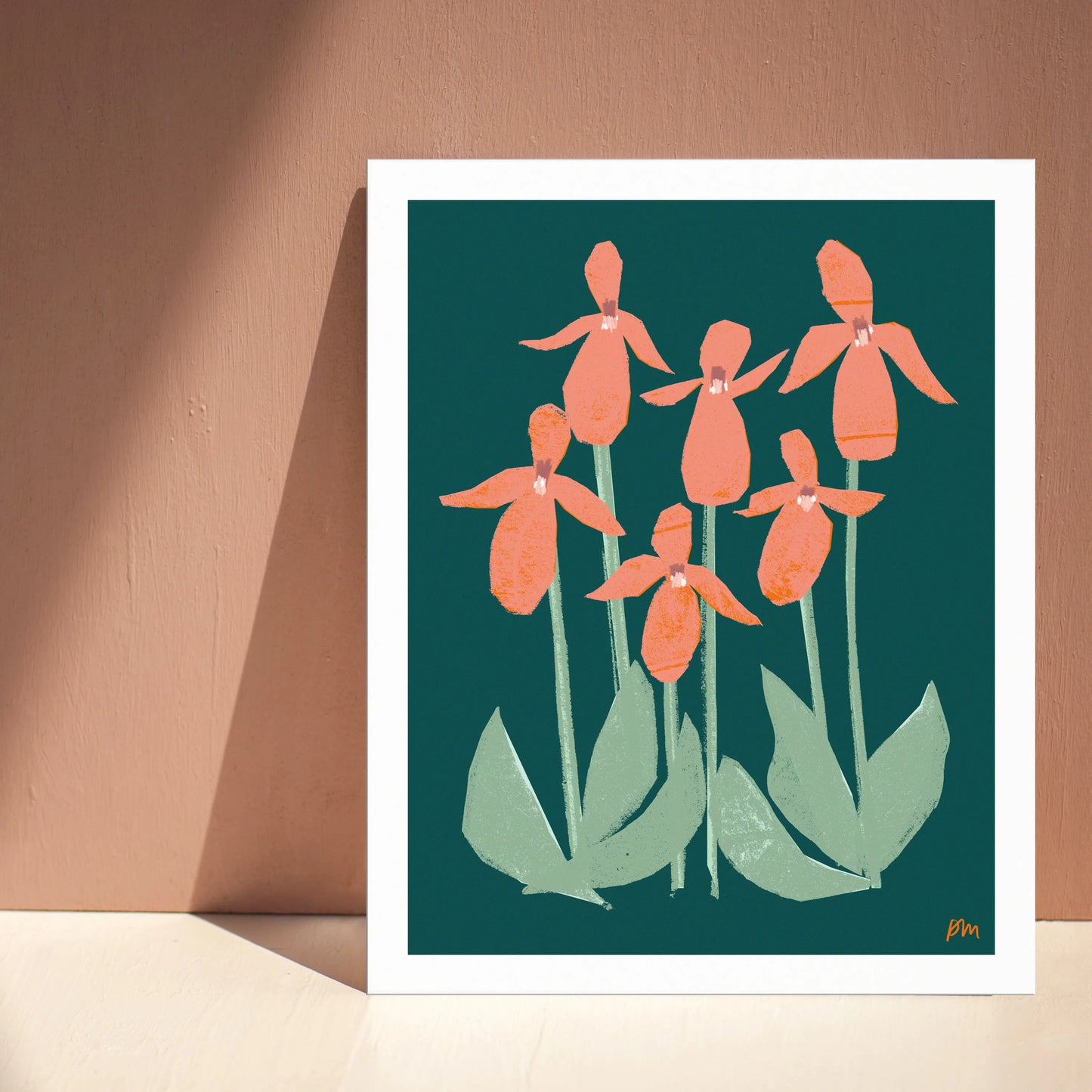 Kautzi Illustrations 8×10 Pink Lady’s Slippers art print leaning against a wall with natural light, showing stylized coral-pink wildflowers on a deep green background, inspired by Maritime forest flora.