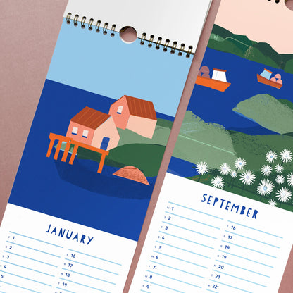 Close-up of January and September pages from the 2027 Kautzi calendar, showing Maritime fishing village illustrations with a wharf cottage and a coastal meadow of daisies.