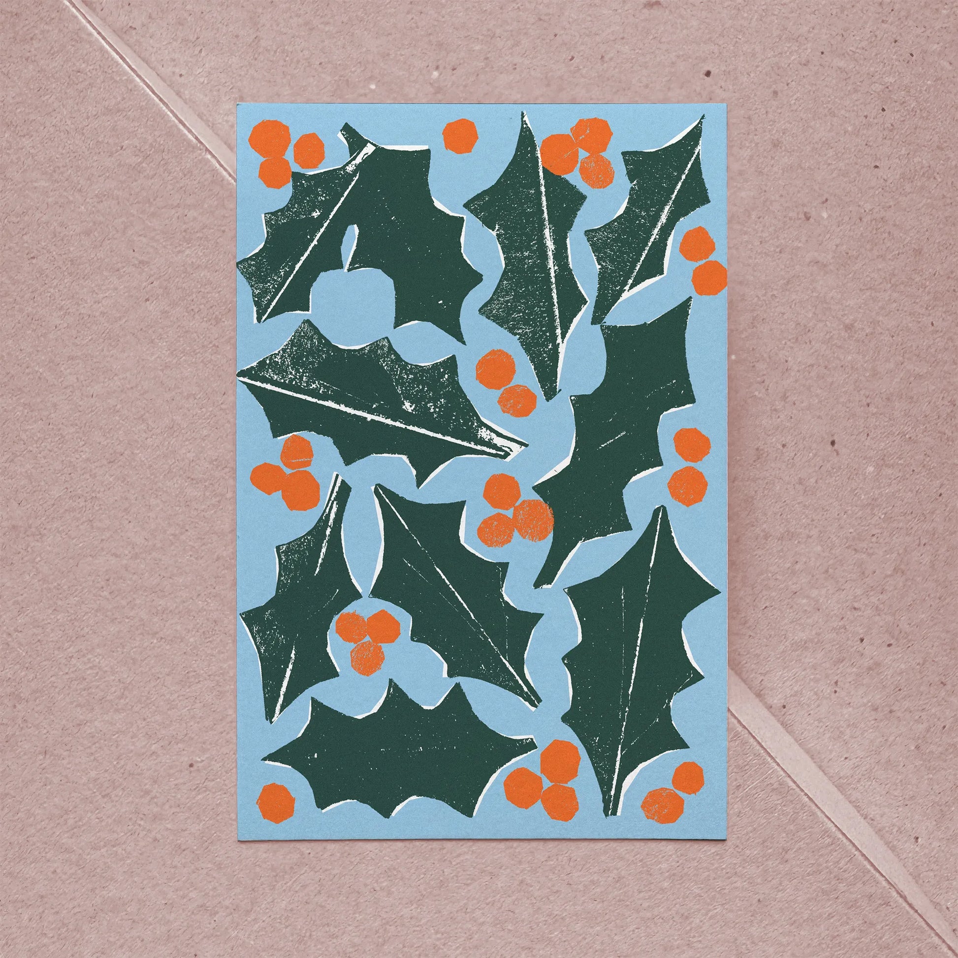 Full front view of holiday card showing holly leaves and orange berries in bold graphic style.