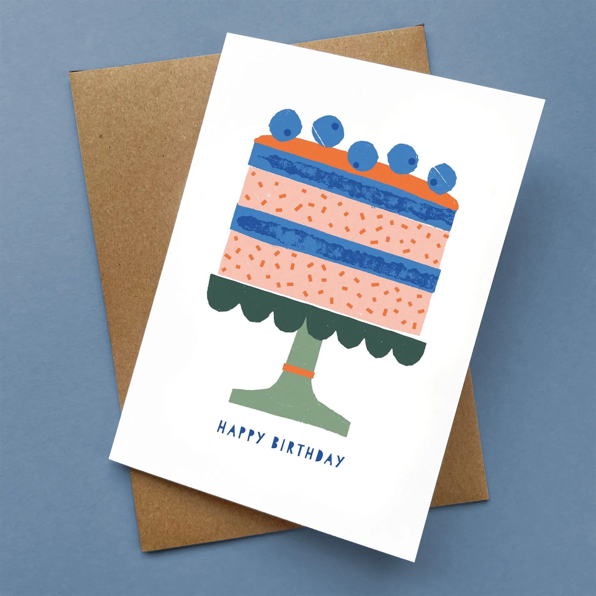 Kautzi greeting card showing a stylized birthday cake topped with blueberries and “Happy Birthday” text, paired with a kraft envelope – designed in Cape Breton, Nova Scotia.