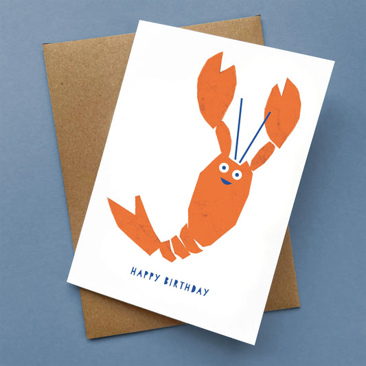Kautzi Happy Birthday card with orange lobster illustration on white background, paired with a kraft envelope – designed in Cape Breton, Nova Scotia.