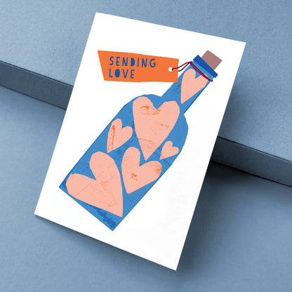 Kautzi Sending Love card at angle – Cape Breton papercut illustration.