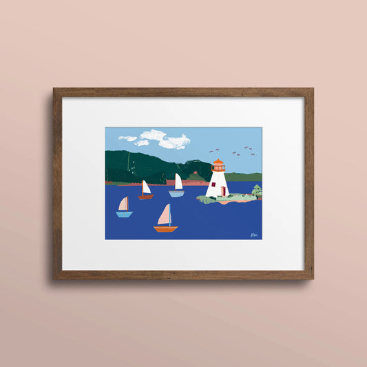 Framed 5x7 art print of sailboats and the Kidston Island Lighthouse, shown with a white mat and dark wood frame against a pale pink wall