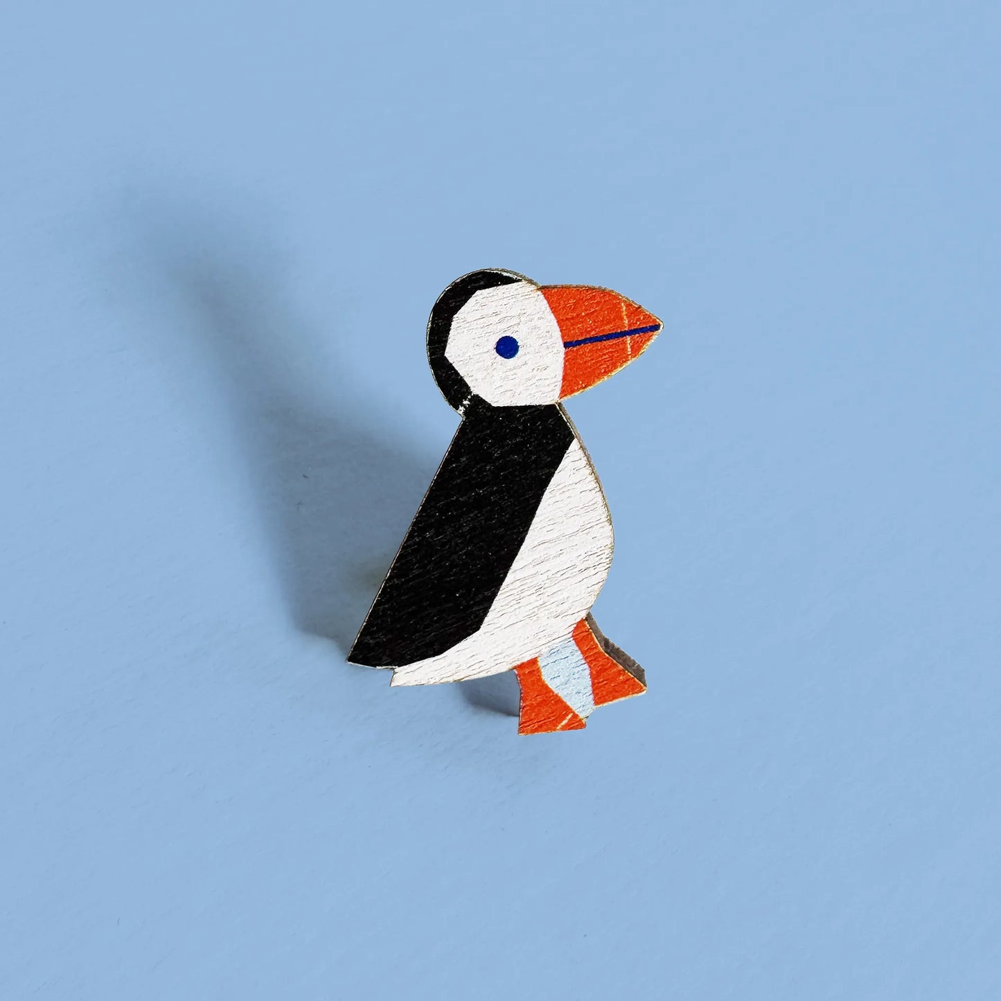 Close-up of Kautzi maple wood veneer puffin pin badge with black, white, and orange details, inspired by Nova Scotia seabirds