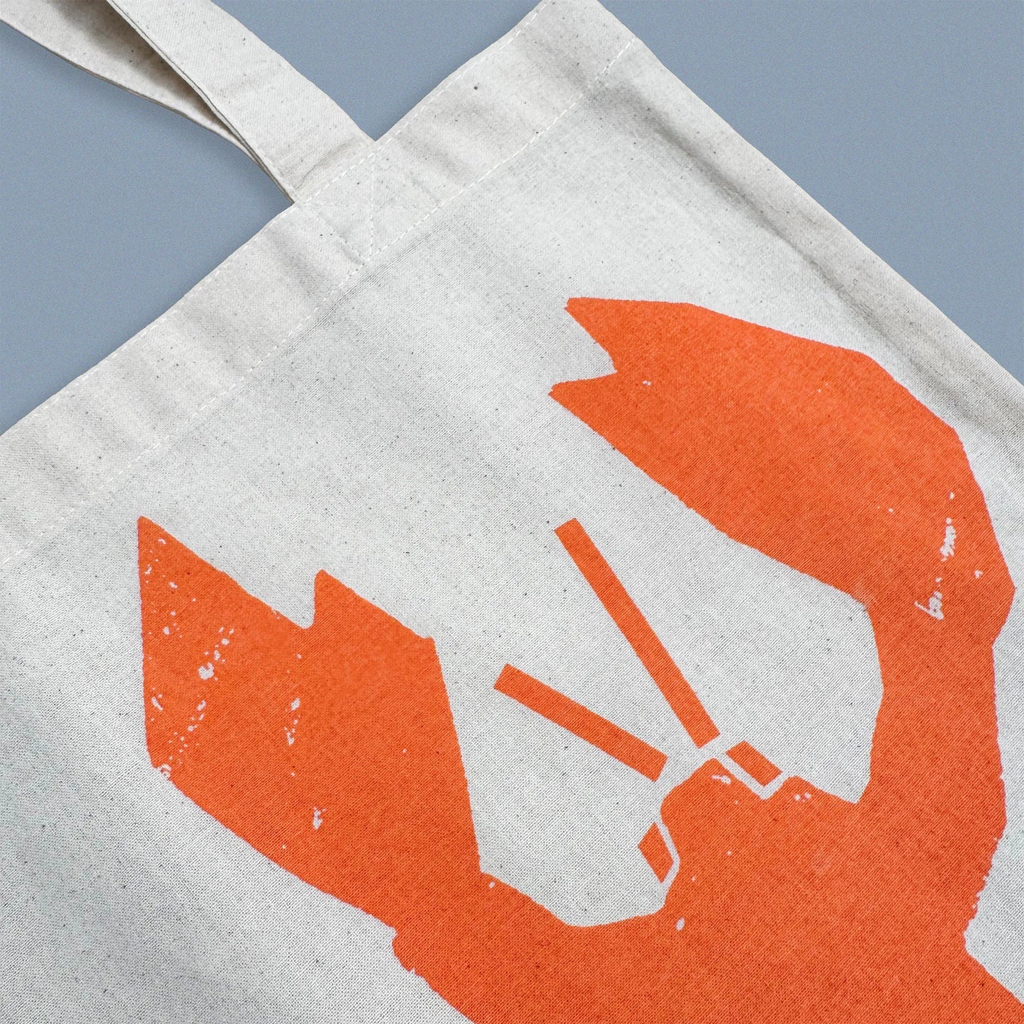 Detail of orange lobster illustration screen-printed on Kautzi cotton tote bag, showing fabric texture and print, Cape Breton, Nova Scotia, Canada.