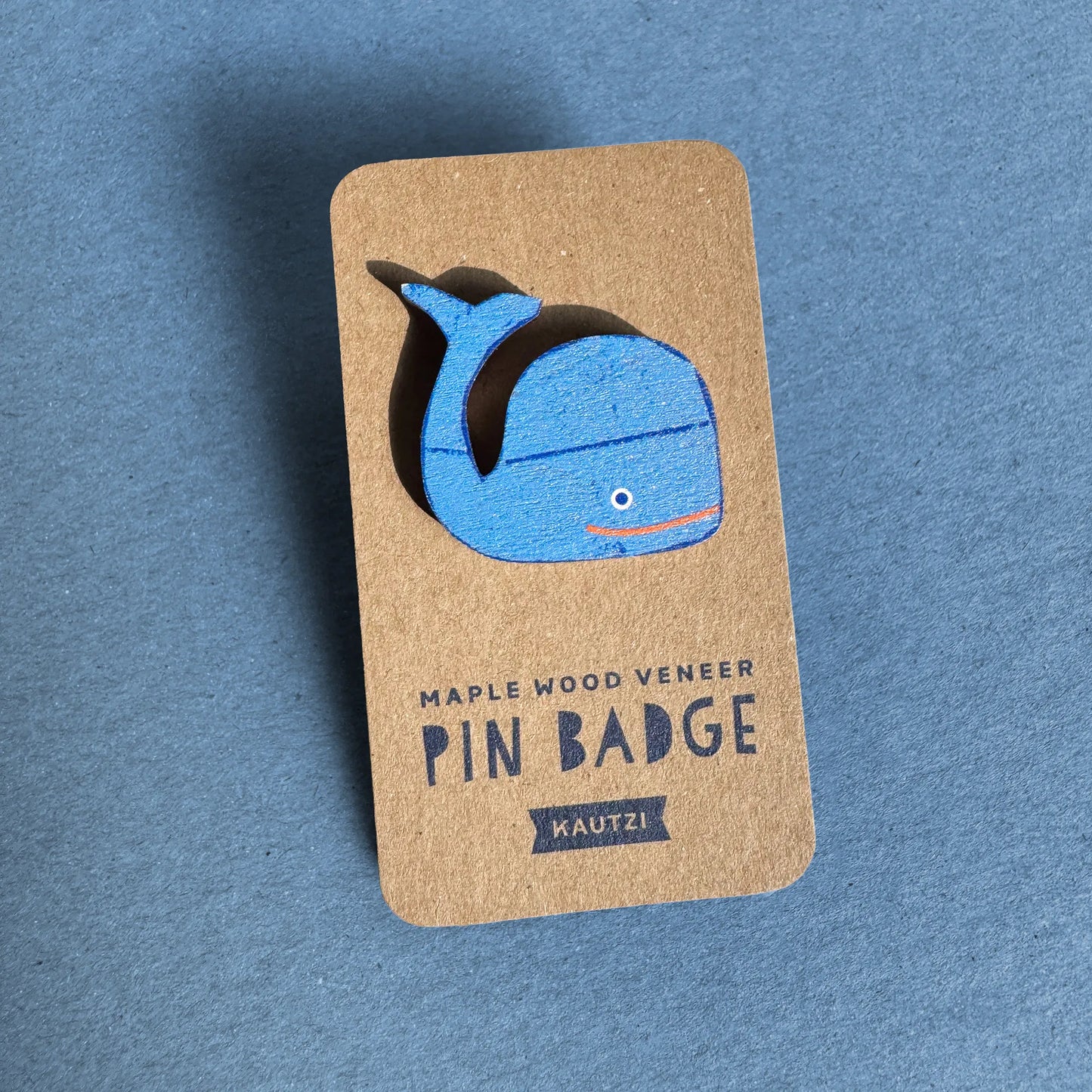Kautzi maple wood veneer whale pin badge on kraft display backing, bright blue whale design inspired by the waters of Nova Scotia