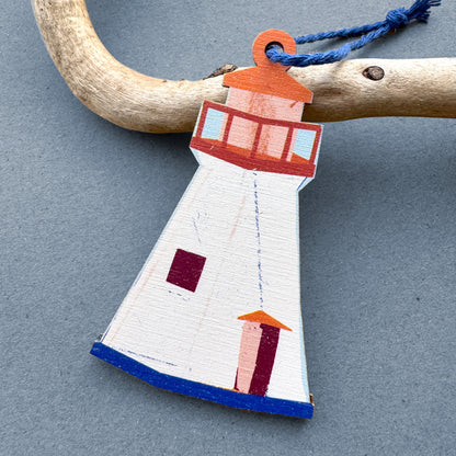 Kautzi wooden lighthouse ornament hanging from driftwood – illustrated Cape Breton, Nova Scotia lighthouse design in cream, red and blue with navy cord