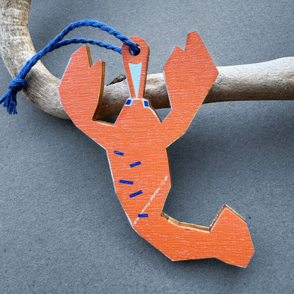 Kautzi wooden lobster ornament hanging from driftwood – bright orange East Coast lobster illustration inspired by Nova Scotia, Canada