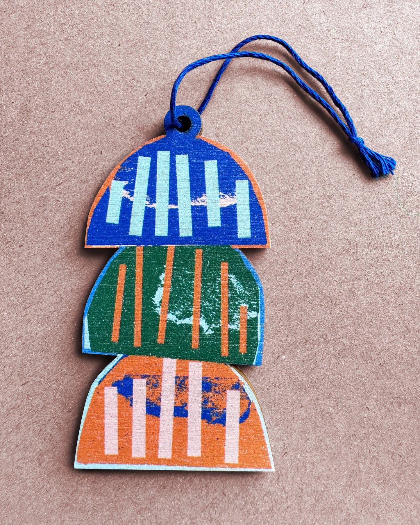 Flat lay of a colourful lobster trap wooden ornament with blue string, designed by Kautzi in Cape Breton, Nova Scotia.