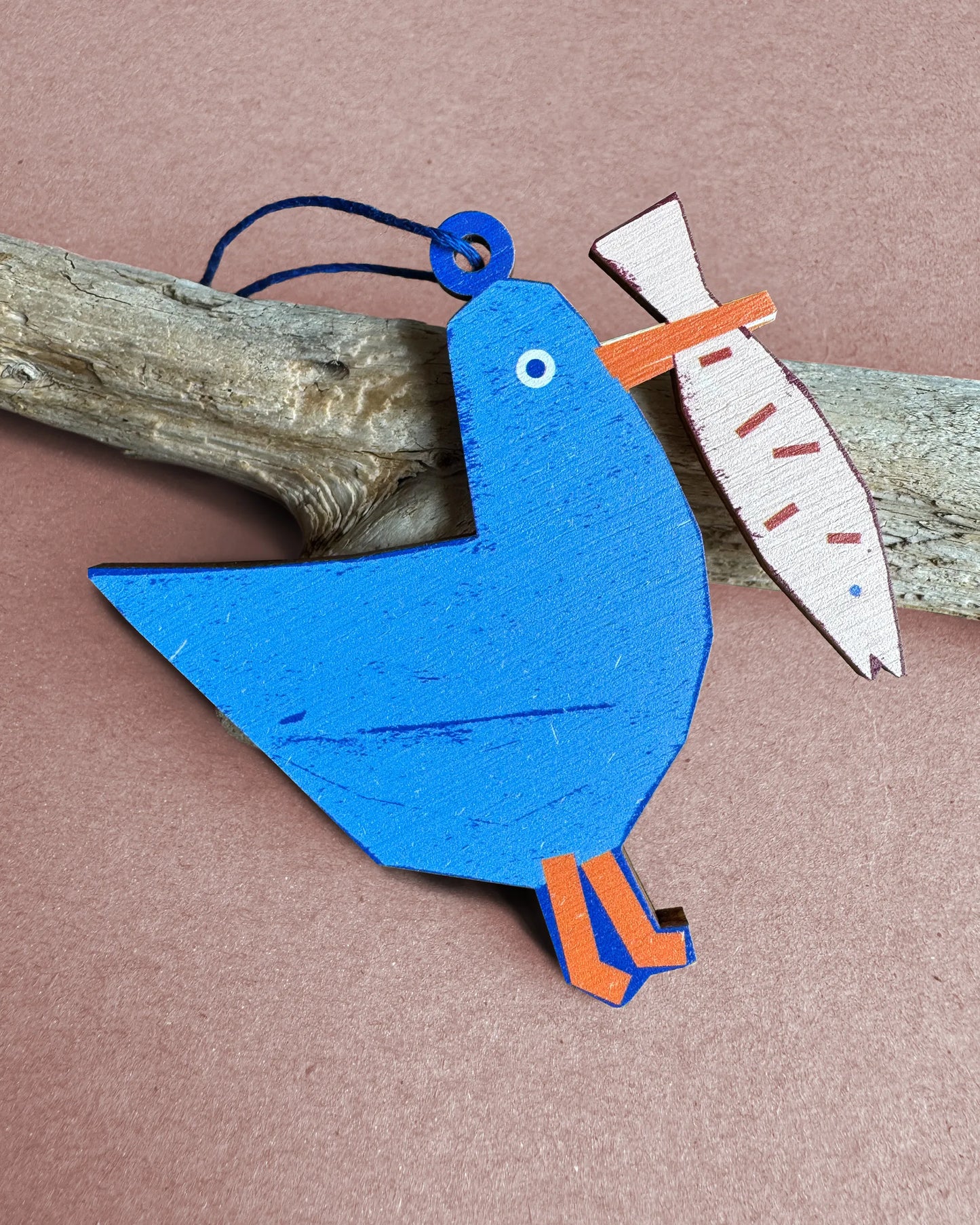 Blue wooden seagull ornament holding a fish, designed by Kautzi in Cape Breton, Nova Scotia.