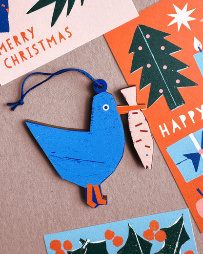 Kautzi seagull wooden ornament displayed with holiday cards featuring coastal motifs and bright colours.