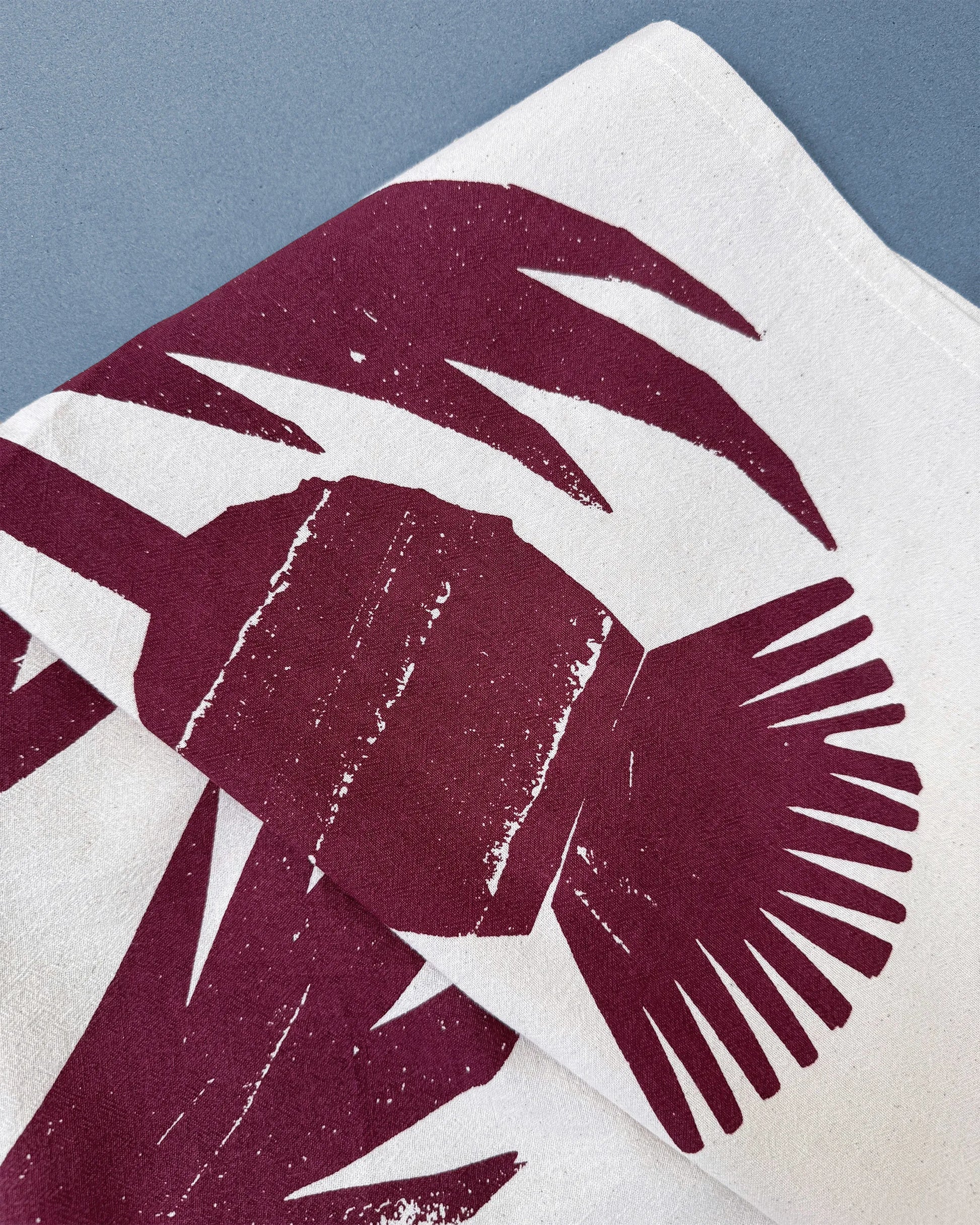 Kautzi Wild Thistles tea towel detail showing deep plum thistle illustration screen printed on natural white cotton, photographed in Nova Scotia.